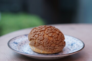 A choux cream puff bakery pastry on the plate.