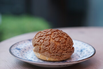 A choux cream puff bakery pastry on the plate.