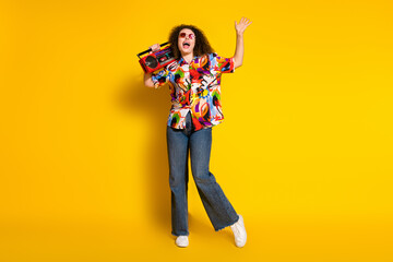 Full size photo of attractive young woman boombox listen music dressed stylish colorful print clothes isolated on yellow color background