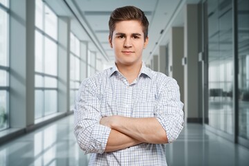 Ambitious handsome male employee posing in office