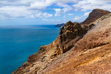 Fototapeta na wymiar The magnificent volcanic cliffs of the Atlantic Ocean coast near the lighthouse El Faro de la Entallada, Fuerteventura, Canary Islands, Spain