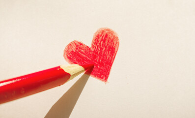 Hand drawn red heart on white paper close up in sun light as illustration of love and romantic relationship