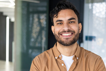 Portrait of a smiling young man in a modern office environment