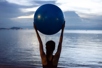 Yoga woman on the ocean during amazing sunset. Fitness and healthy lifestyle.