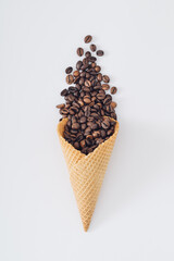 Ice cream cone with coffee beans on white background. Minimal summer creative concept. Trendy ice...