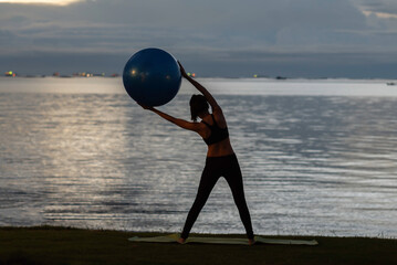 Yoga woman on the ocean during amazing sunset. Fitness and healthy lifestyle.
