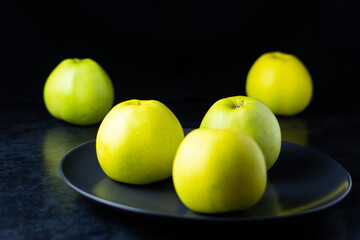 Fresh ripe green apples on wooden table against dark background, space for text