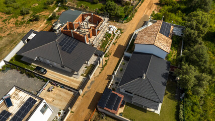 Villas under construction but almost completed in a new neighborhood on the outskirts of a city.