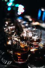 Bartender Preparing Multiple Whiskey Cocktails at a Busy Bar