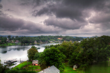 Lake Hamilton.  Overlooking a tranquil Lake Hamilton waterfront community, the view shows houses scattered around a calm lake under a dramatic, cloud-filled sky. 