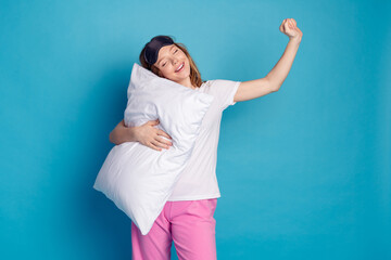 Photo of adorable pretty girl wear white trendy pajama raise hand wake up isolated on blue color...