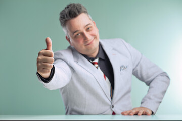 Joyful businessman gives enthusiastic thumbs up approval