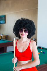 Leisure beautiful brunette in a billiard bar on vacation at a resort.