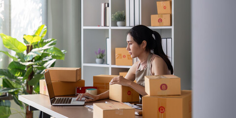 Small business owner preparing packages for shipment at home office. Concept of ecommerce, online sales, and entrepreneurship