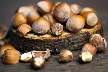 Close-up. Hazelnuts in shell and without on a wooden stand.