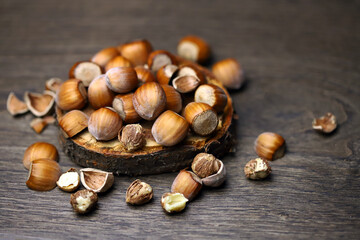 Close-up. Hazelnuts in shell and without on a wooden stand.