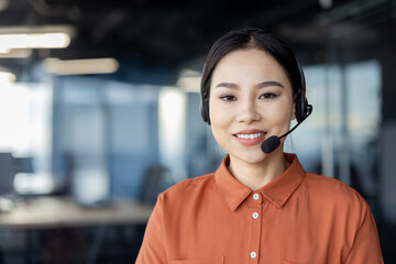 Smiling customer service representative with headset working in a modern office environment....