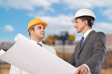 Architect and Engineer checking documents at construction site.
