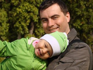 Portrait of little adorable smiling girl and father in spring outdoors.