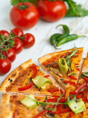 vegetarian pizza with cheese, tomato, pepper and avocado in white wooden desk.Top view