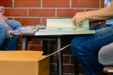 Hands of businessman working in stacks of paper files for searching information or arranging documents of unfinished documents on work desk home office, business report papers, unfinished documents.