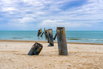 Beautiful view of leaning pillars of the old pier. Slanted concrete pole beach. Abandoned fishing...
