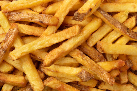 Fresh baked French peel potato fries full frame as background close up