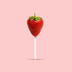 Creative food photography featuring strawberry designed to look like lollipop on soft pink...