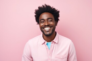 Portrait of a joyful afro-american man in his 30s smiling at the camera in pastel or soft colors...