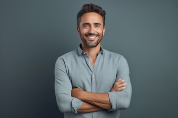 Obraz premium Portrait of a grinning man in his 30s with arms crossed while standing against pastel or soft colors background