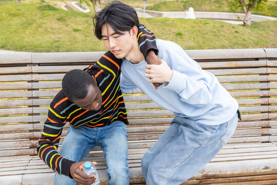 Young man assisting friend experiencing hypoglycemic episode