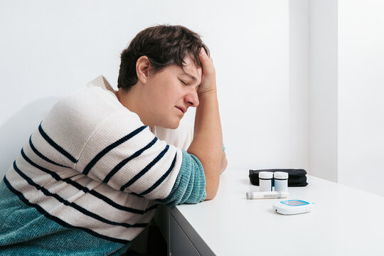 Woman experiencing symptoms of hypoglycemia at table