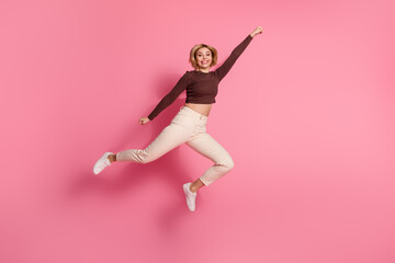 Photo of charming cheerful crazy girl wear trendy brown clothes fly empty space isolated on pink...