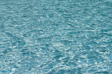 風に揺れるプールの透明な水　夏イメージ