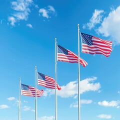 American flags waving atop poles against a blue sky backdrop for a patriotic holiday celebration.