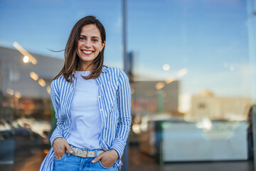 Young latin woman in casual clothing in the street looking at camera, during early morning....