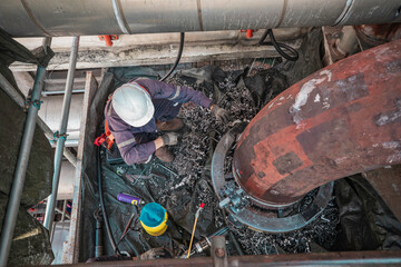 Male worker inspection at steel long pipes and pipe elbow in station oil factory during refinery...