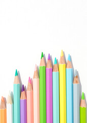 Pastel colored pencils in uneven row on a white background