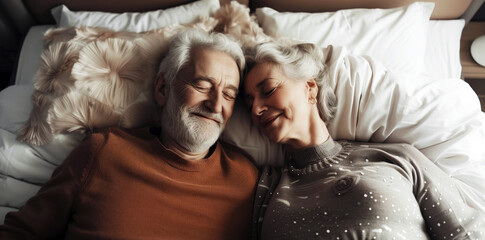 Elderly couple peacefully resting and smiling on a bed with plush pillows, creating a warm, intimate, and serene atmosphere - Powered by Adobe