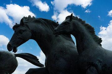 Horse statutes with dramatic clouds in the background at Empowered Field. Blue sky's behind running horse statue. Very close shot of horses. Horses running up a stream. © Visual Art Complex