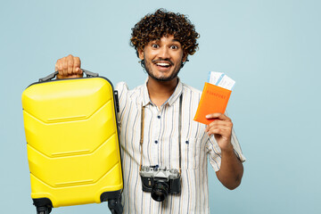 Traveler smiling Indian man wear white casual clothes hold bag passport ticket isolated on plain...