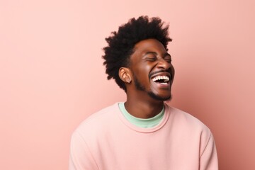 Portrait of a content afro-american man in his 20s laughing isolated on pastel or soft colors background