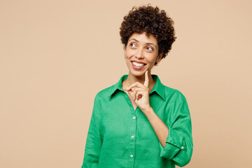 Young woman of African American ethnicity wear green shirt casual clothes put hand prop up on chin,...