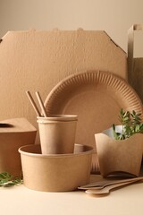 Eco friendly food packaging. Paper containers, tableware and green twigs on white table