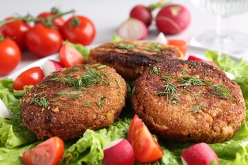 Delicious vegetarian cutlets and vegetables on plate, closeup