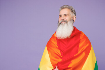 Happy fun elderly bearded gay man 50s years old wears casual clothes wrapped in striped rainbow...