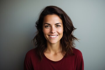 Fototapeta premium Portrait of a tender woman in her 30s smiling at the camera in minimalist or empty room background