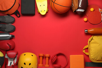 Frame made of different sports equipment on red background, flat lay. Space for text