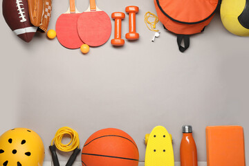 Frame made of different sports equipment on light grey background, flat lay. Space for text