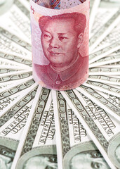 yuan banknote, surrounded by 100 dollar bills. American market protectionism concept, USA vs China...